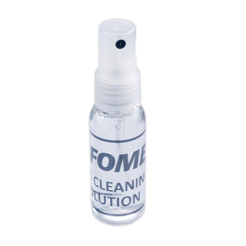 Fomei lens cleaning kit featuring microfiber cloth, cleaning solution, and brush for camera lens maintenance.